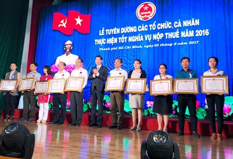 Phó Chủ tịch UBND TP. Hồ Chí Minh Trần Vĩnh Tuyến khen thưởng người thực hiện tốt nghĩa vụ thuế. Ảnh Đ.Doãn