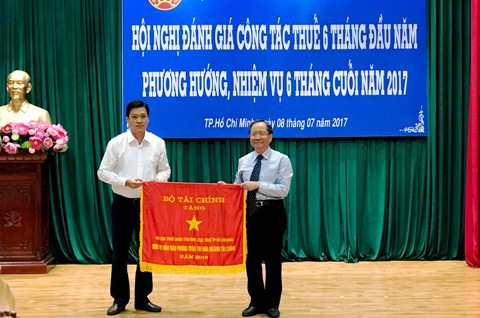 Thứ trưởng Đỗ Hoàng Anh Tuấn trao cờ Đơn vị dẫn đầu phong trào thi đua ngành Tài chính cho lãnh đạo Chi cục thuế Tân Bình (TP. Hồ Chí Minh). Ảnh Đ.Doãn